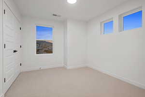 Empty room featuring carpet flooring and baseboards