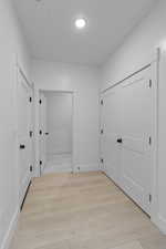 Hallway featuring light wood-type flooring and baseboards