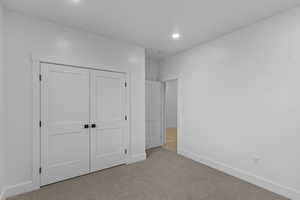 Unfurnished bedroom featuring carpet floors, a closet, and recessed lighting