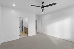 Unfurnished bedroom with ensuite bath, light carpet, a ceiling fan, and recessed lighting