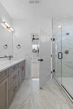 Full bathroom with vanity, light marble finish floors, a marble finish shower, and a ceiling fan