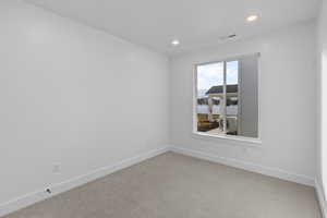 Empty room with carpet flooring and recessed lighting