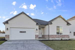 Ranch-style home featuring brick siding, concrete driveway, a front yard, and an attached garage