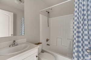 Bathroom with shower / bathtub combination with curtain and vanity