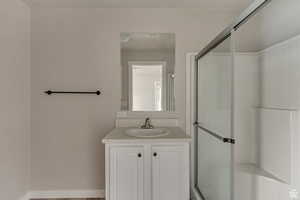 Full bath featuring a shower stall, vanity, and wood finished floors