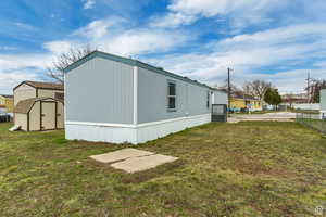 View of side of home with a storage shed
