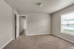 Unfurnished room with light carpet and baseboards