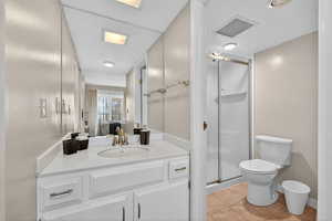 Ensuite bathroom with a stall shower, light tile patterned floors, and vanity