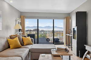 Living area with healthy amount of natural light, a mountain & city views, and wood finished floors