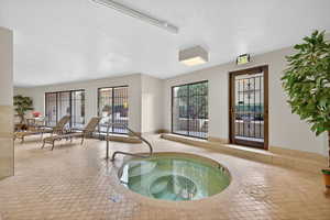 View of pool featuring a hot tub and a swimming pool