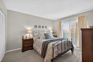 Bedroom featuring light carpet and a closet