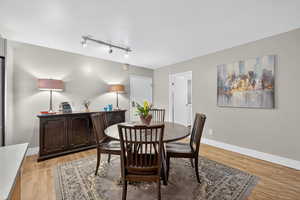 Dining space featuring light wood-style flooring and track lighting