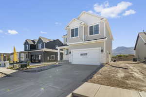 View of front facade featuring a porch, concrete driveway, an attached garage, and brick siding