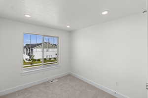 Carpeted empty room with recessed lighting