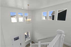 Staircase featuring a chandelier and baseboards