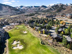 Aerial view of property's location with a mountainous background and a golf club