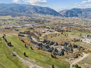 Aerial overview of property's location with a water and mountain view and nearby suburban area