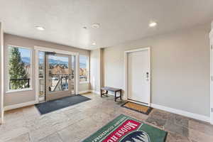 Entrance foyer featuring stone tile floors, recessed lighting, and a textured ceiling