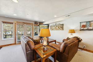 Living area featuring a textured ceiling and recessed lighting