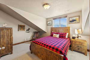 Bedroom featuring light carpet and a textured ceiling