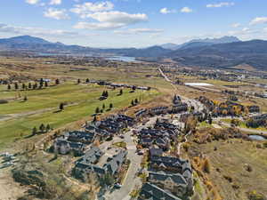 Aerial view of property's location with a water and mountain view and nearby suburban area