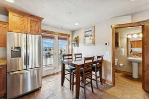 Dining area featuring stone tile flooring and recessed lighting
