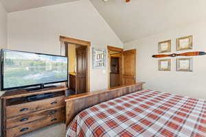 Bedroom with carpet floors and high vaulted ceiling