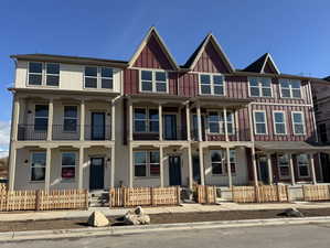 View of front of house with a fenced front yard, stucco siding, and covered porch