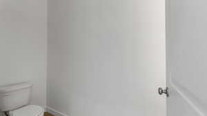 Half bath with toilet and baseboards