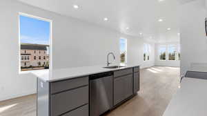 Kitchen with gray cabinets, recessed lighting, a kitchen island with sink, light wood-style flooring, and stainless steel dishwasher