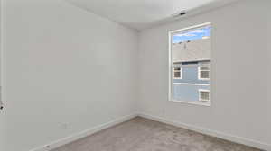 Unfurnished room with light carpet and baseboards