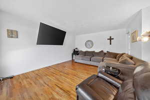 Living area featuring wood finished floors and a textured ceiling