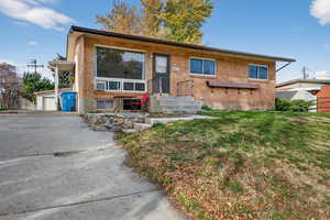 View of front of house featuring a front yard and brick siding