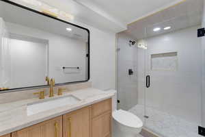 Bathroom with vanity, recessed lighting, and a stall shower