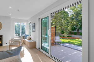 Doorway featuring wood finished floors, a lit fireplace, and recessed lighting