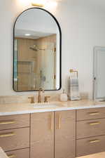 Full bath featuring a stall shower and vanity