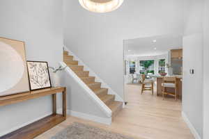 Staircase with wood finished floors, recessed lighting, and a high ceiling