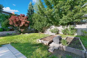 Fenced backyard featuring a vegetable garden