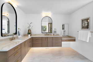 Full bath with double vanity and baseboards