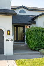 Entrance to property with stucco siding and a garage