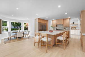 Kitchen featuring tasteful backsplash, light wood-style flooring, a center island, open shelves, and recessed lighting