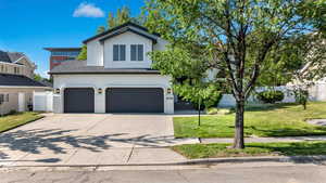 View of front of house with stucco siding, a garage, and driveway