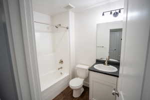 Full bath featuring dark wood-style flooring, vanity, and shower / washtub combination
