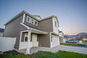 View of front facade featuring a mountain view, concrete driveway, and an attached garage