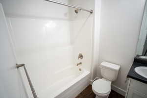 Bathroom with vanity, dark wood-style floors, and bathtub / shower combination