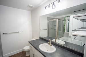 Full bath featuring a shower stall, vanity, dark wood-style flooring, and a tub to relax in