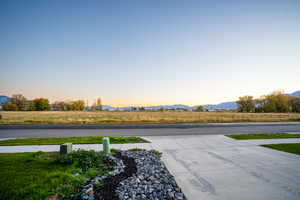View of concrete road with a view of rural / pastoral area and a mountain view