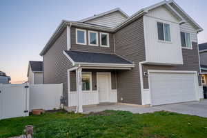View of front of home featuring a gate, an attached garage, concrete driveway, and a porch