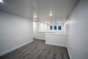 Spare room with recessed lighting and dark colored carpet