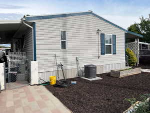View of side of property featuring a gate and a garden